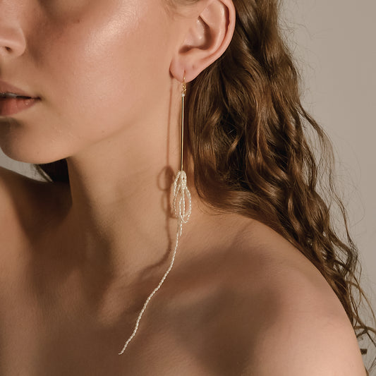 model wearing Aphrodite range, long bar drop with pearl chain earrings, handmade