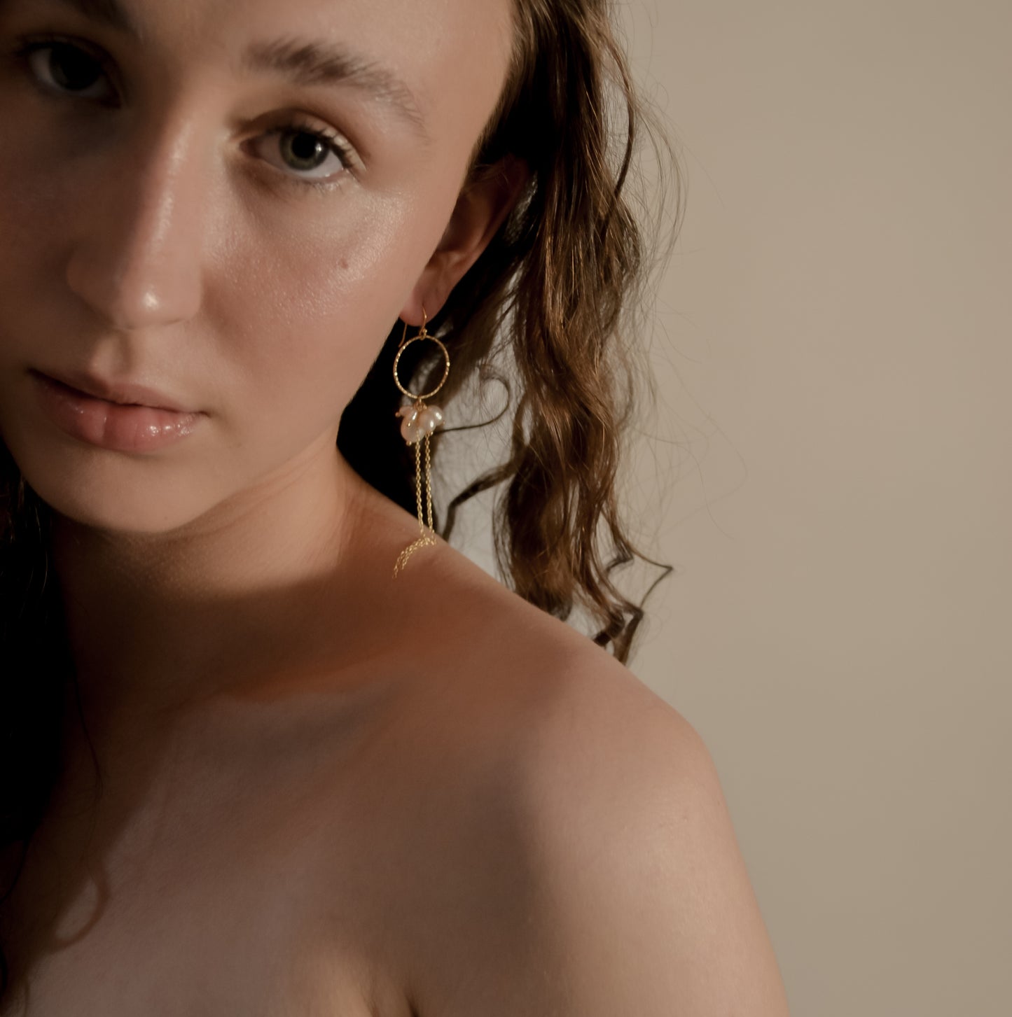 model wearing Arabella cluster pearl with gold chain and hoop earrings