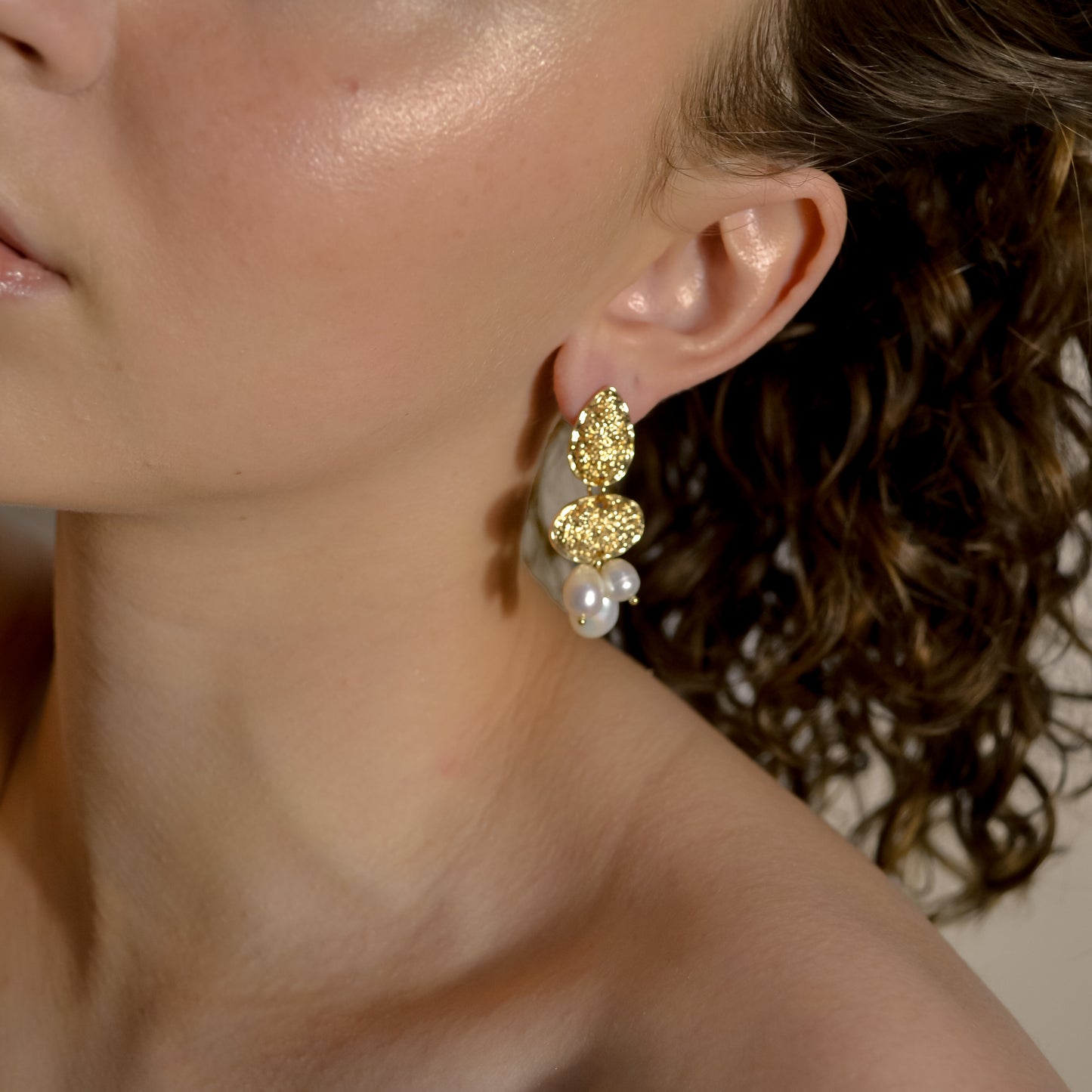 model wearing Clara collection, bridal seed pearl cluster with bold gold stud earrings