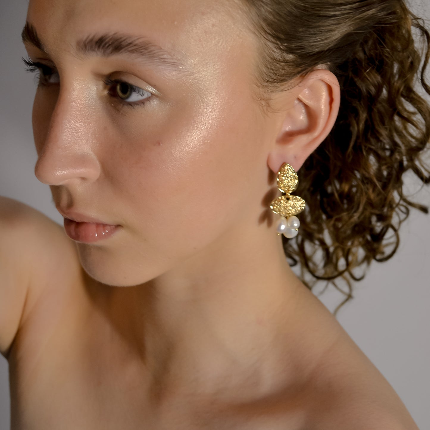 model wearing Clara collection, bridal seed pearl cluster with bold gold stud earrings