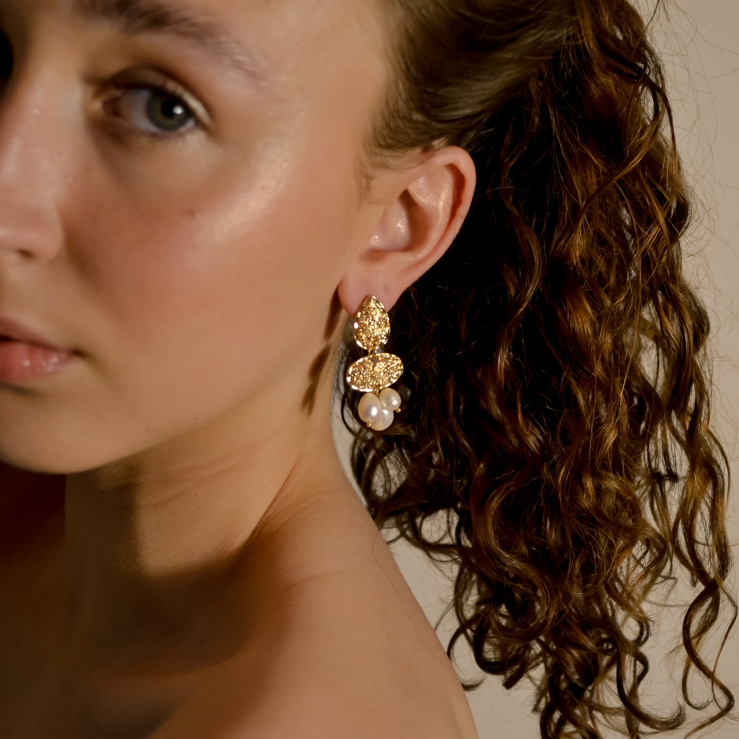 model wearing Clara collection, bridal seed pearl cluster with bold gold stud earrings