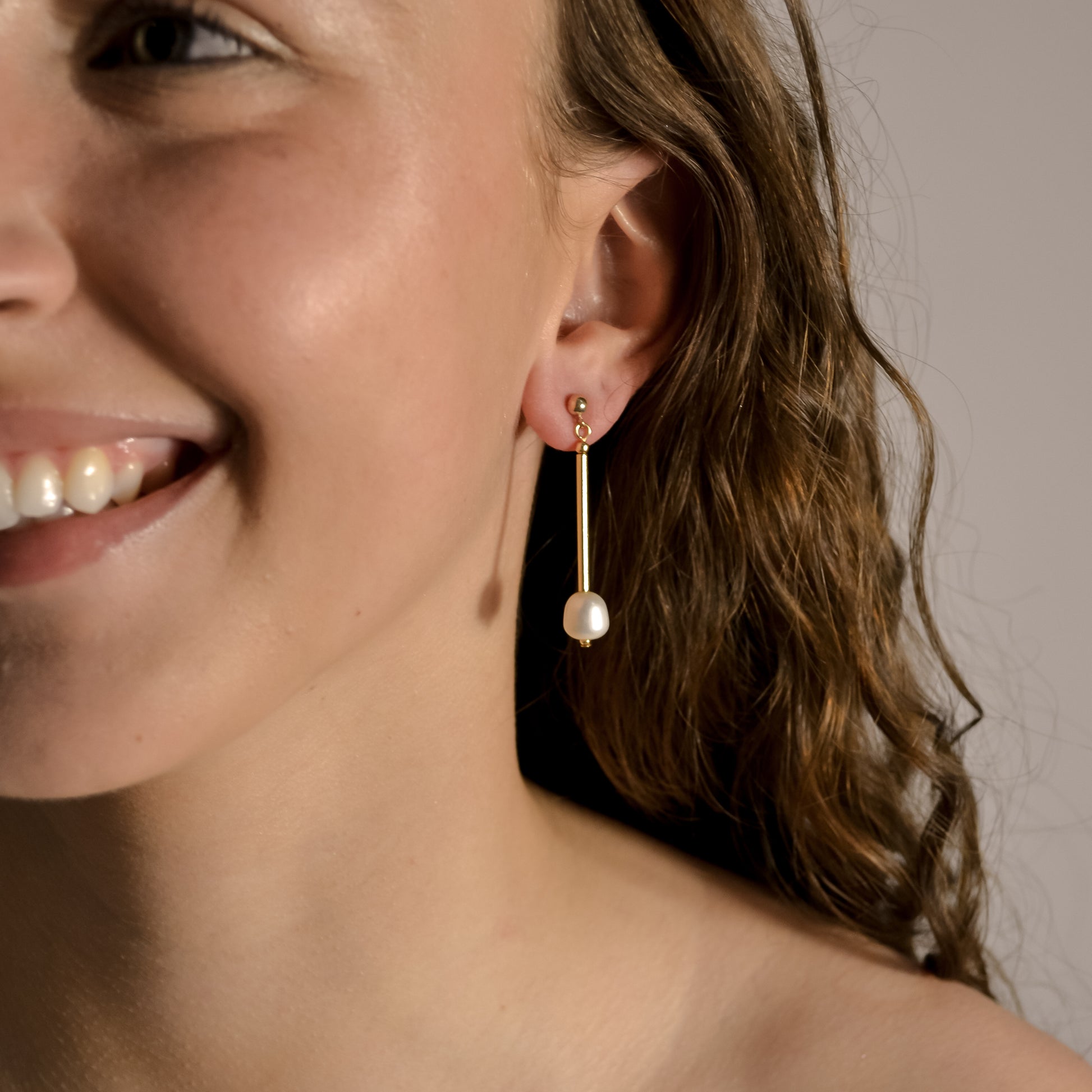 Model wearing Freya short pearl, gold drop earrings