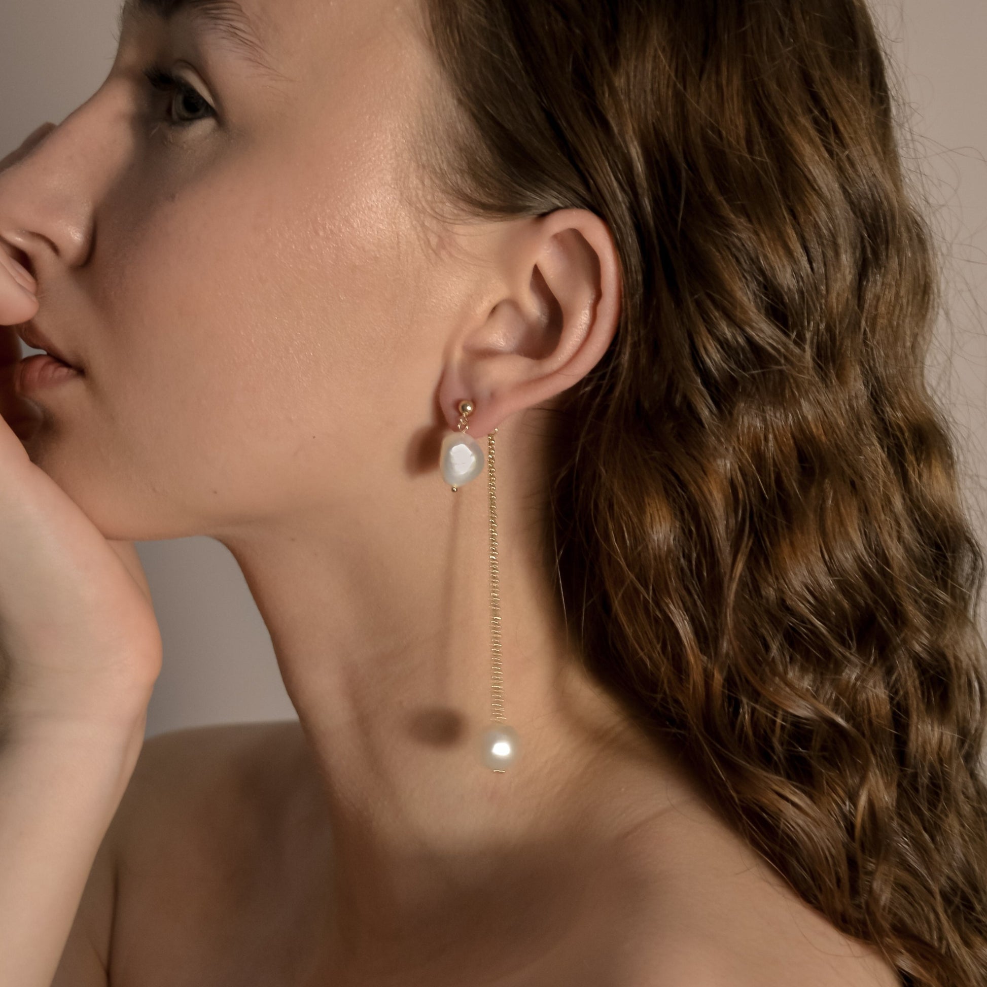 model wearing Lennon gold long chain drop pearl earrings, designer handmade