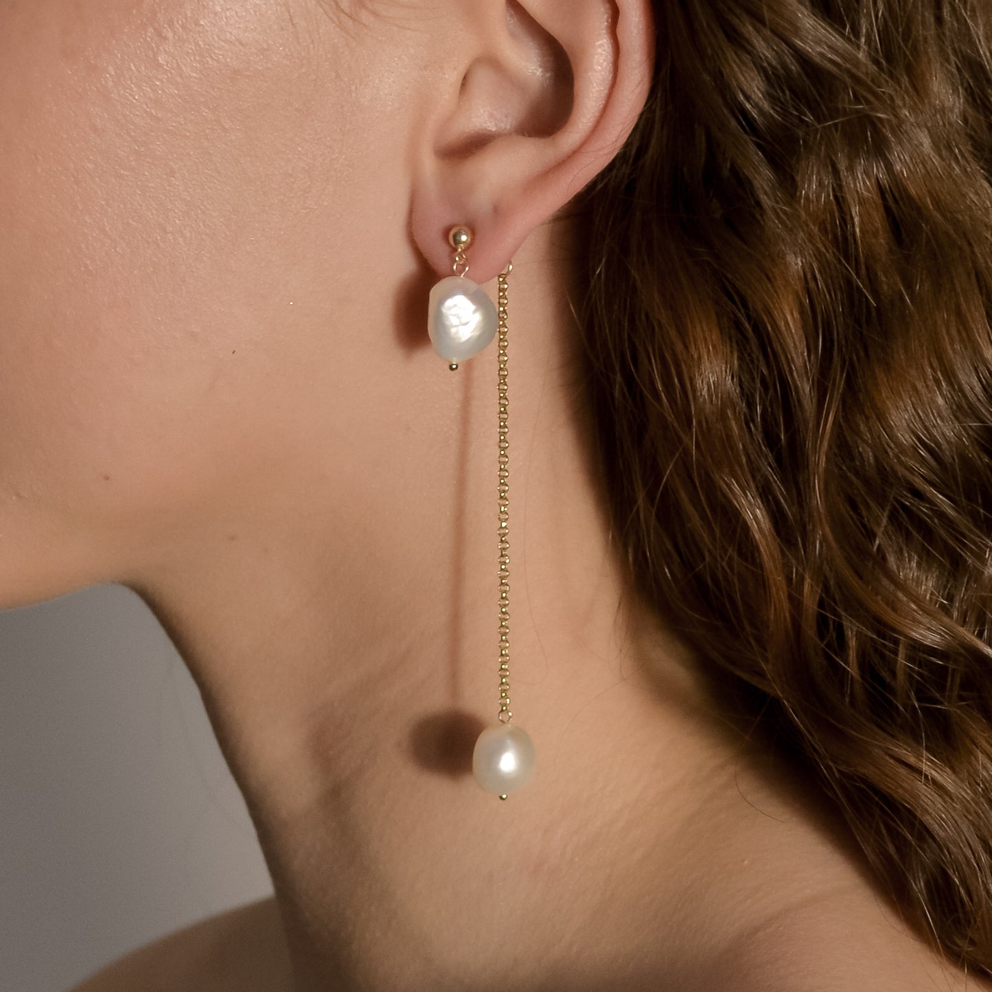 model wearing Lennon gold chain pearl drop earrings