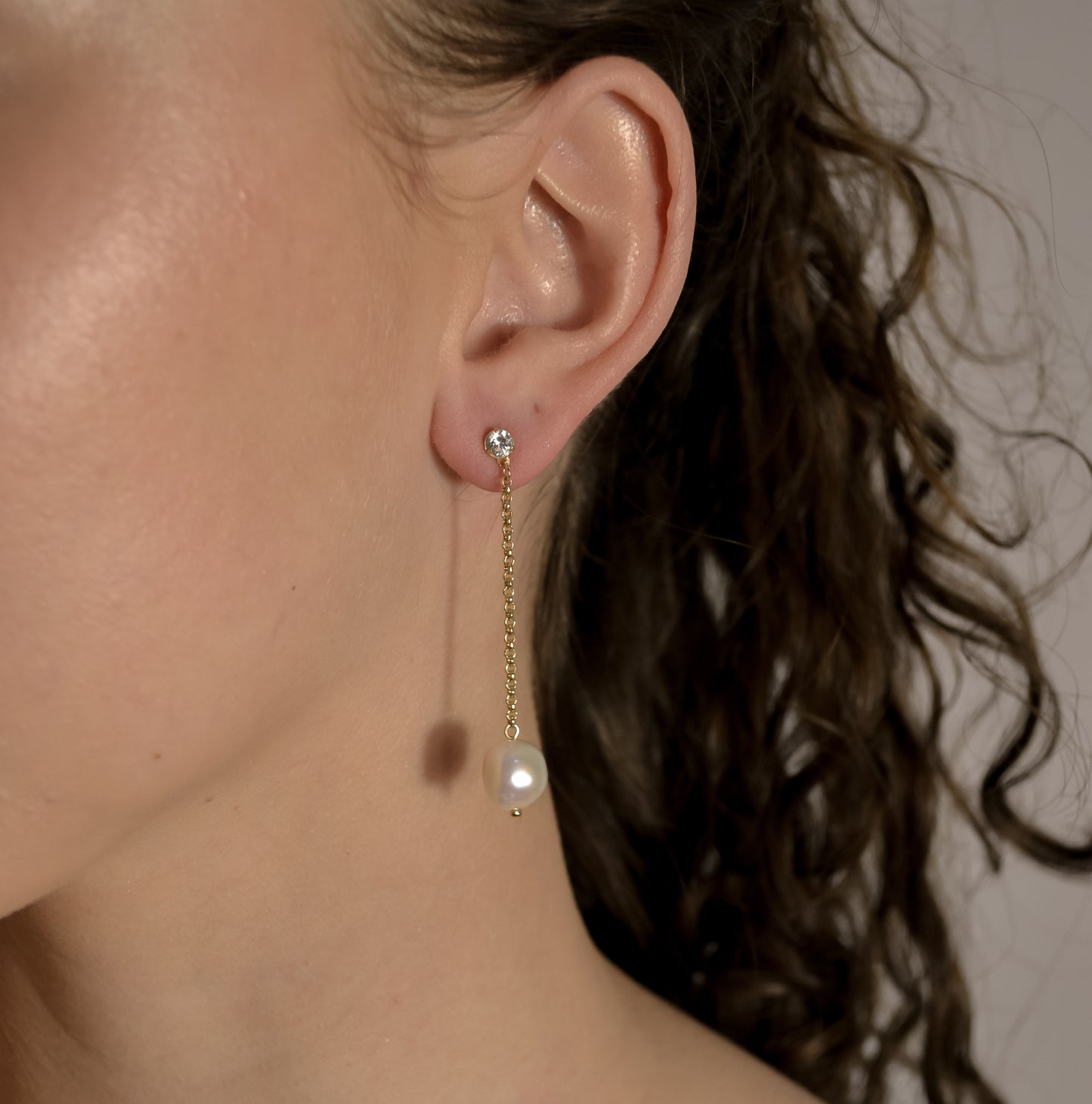 model wearing pearl drop gold chain earrings