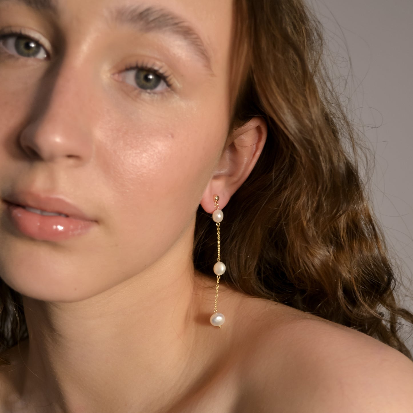 Model wearing Olivia collection, gold chain long drop, ball stud, 3 pearls, handmade earrings