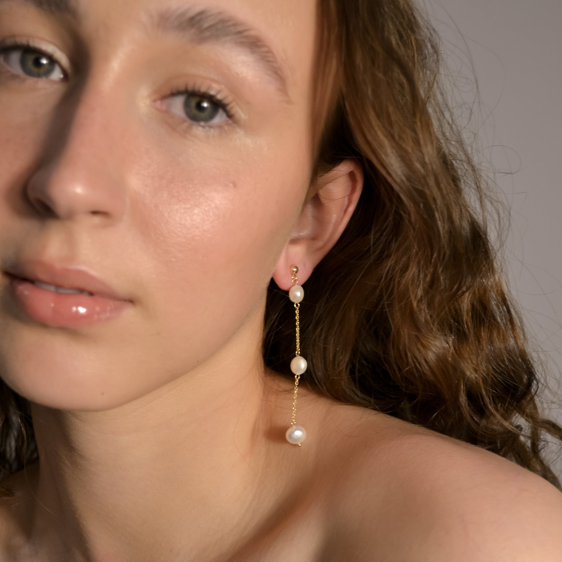 Model wearing Olivia collection, gold chain long drop, ball stud, 3 pearls, handmade earrings