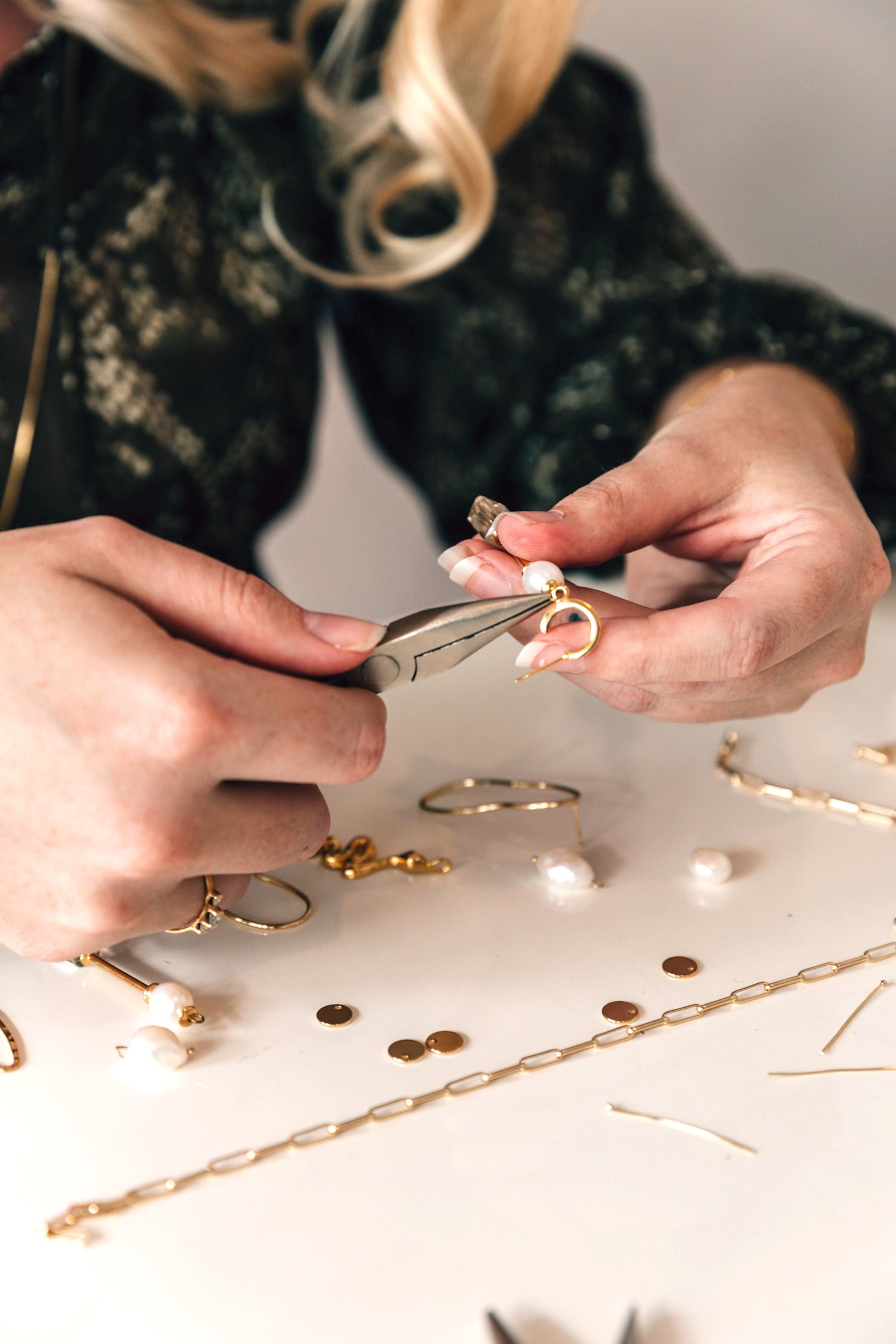 Zoe, founder and designer creating handmade jewelry, in store,