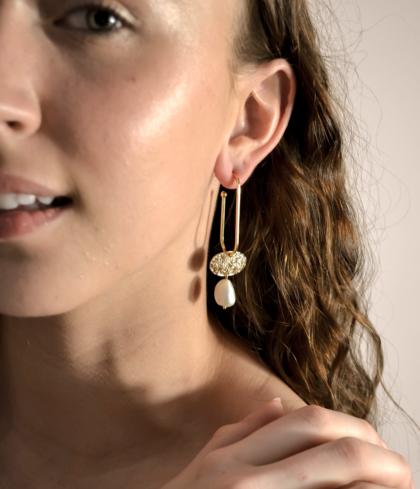 model wearing pearl gold drop earrings