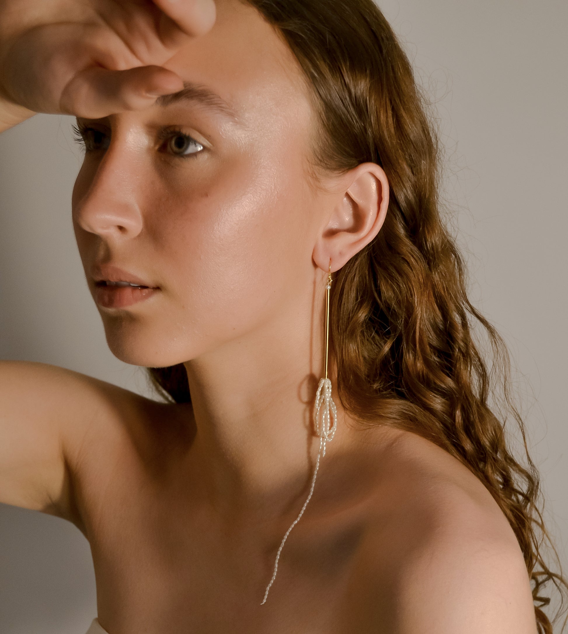 model wearing Aphrodite range, long bar drop with pearl chain earrings, handmade 
