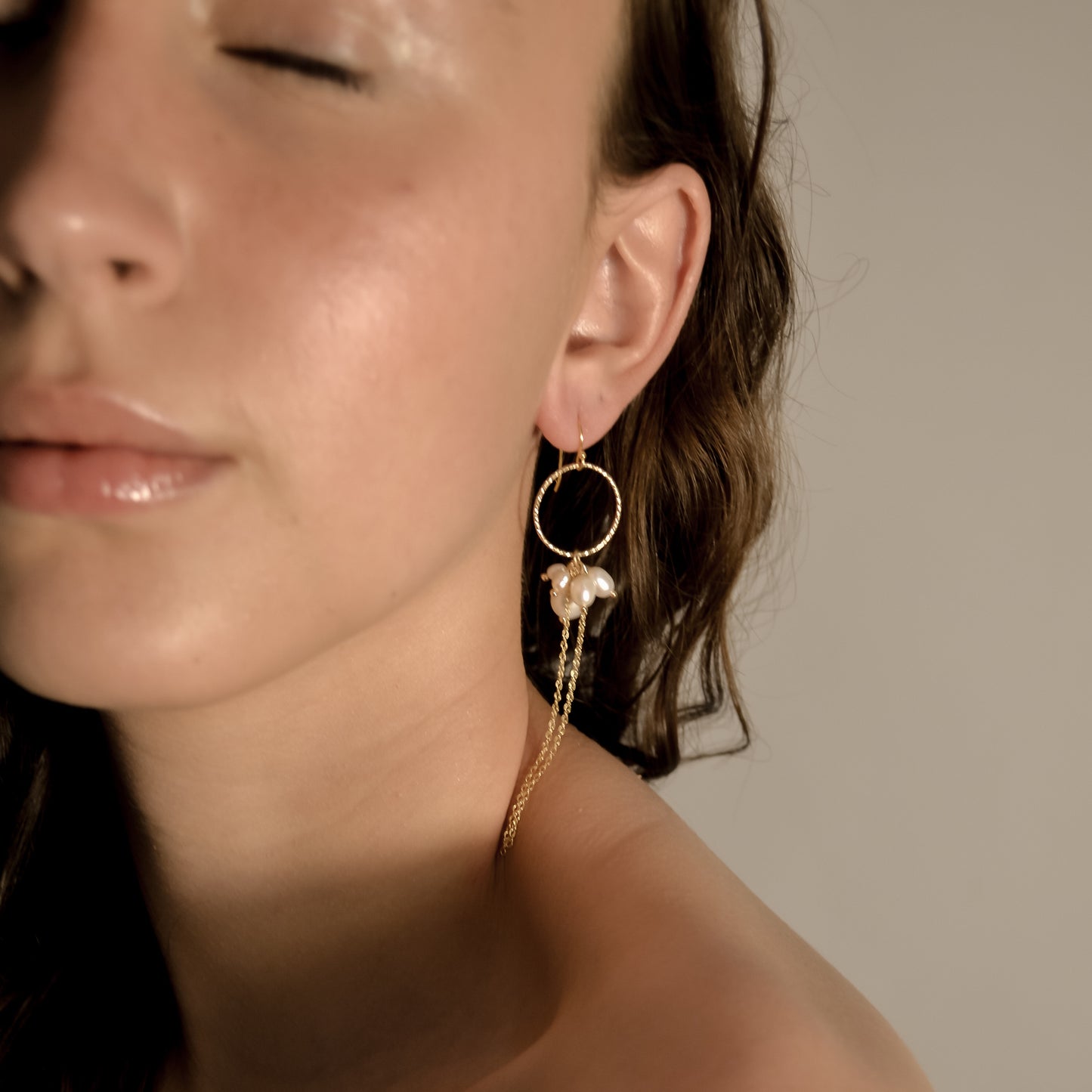 model wearing Arabella cluster pearl and cold drop earrings with gold chain and hoop
