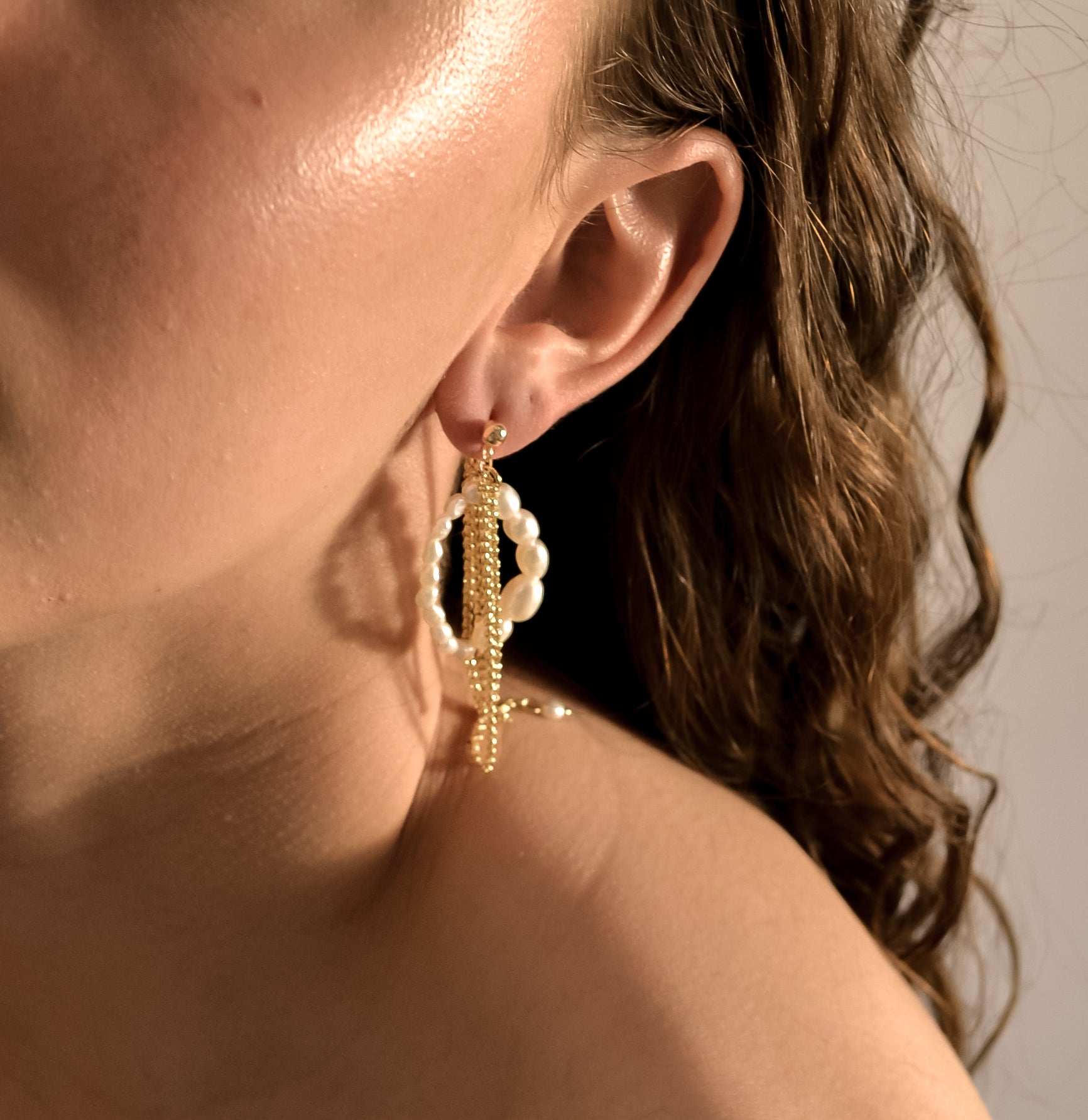 model wearing Calliente range, gold chain layered with pearl hoops, handmade earrings 