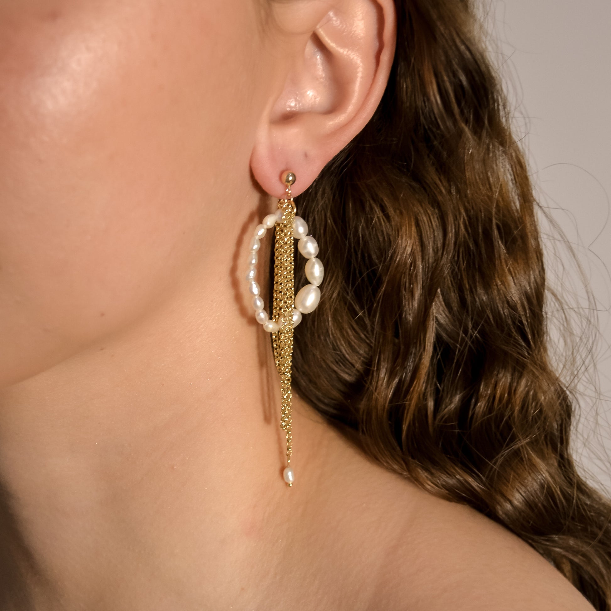 model wearing Calliente range, gold chain layered with pearl hoops, handmade earrings 