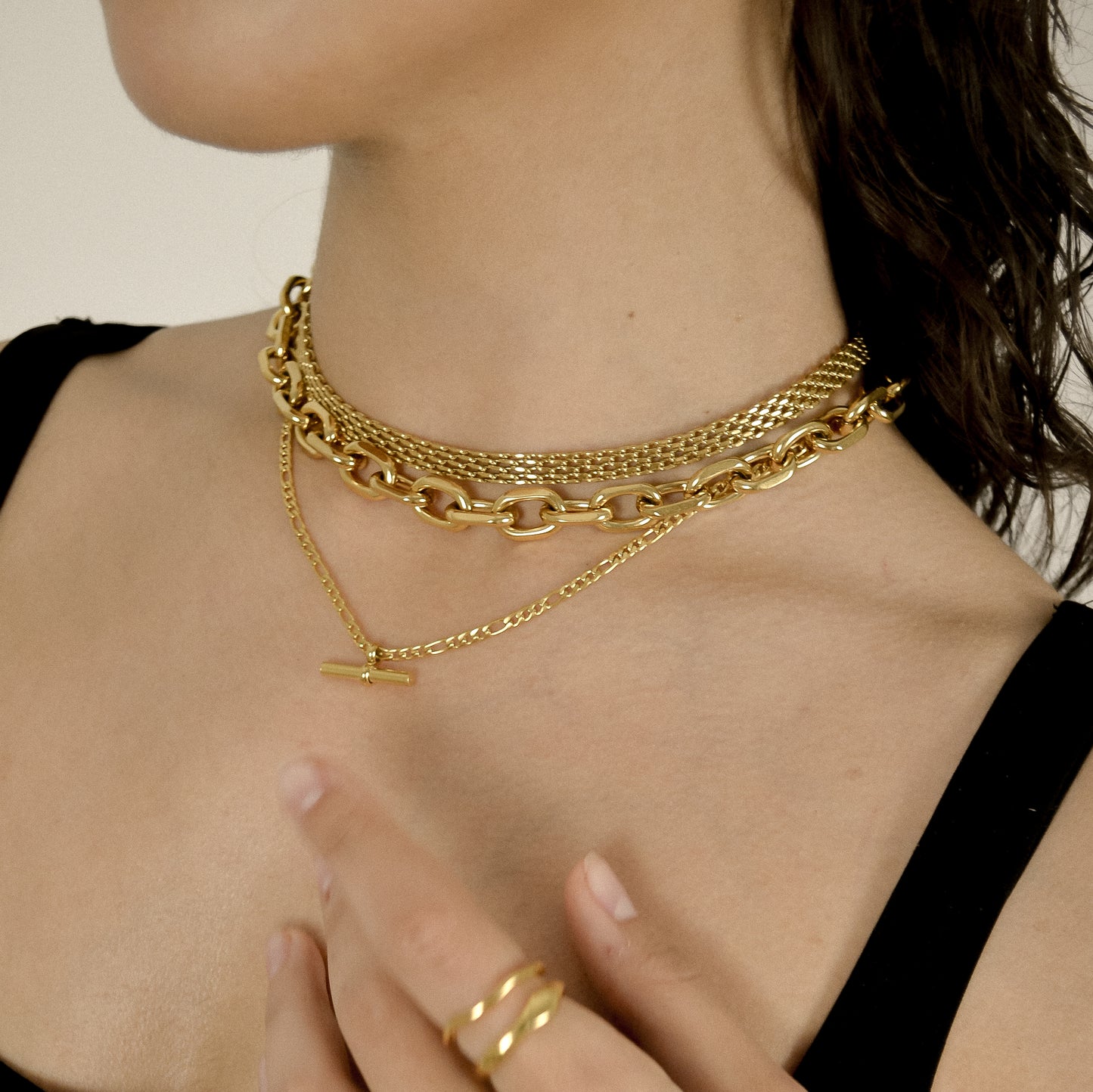 model wearing layered chunky gold chains 