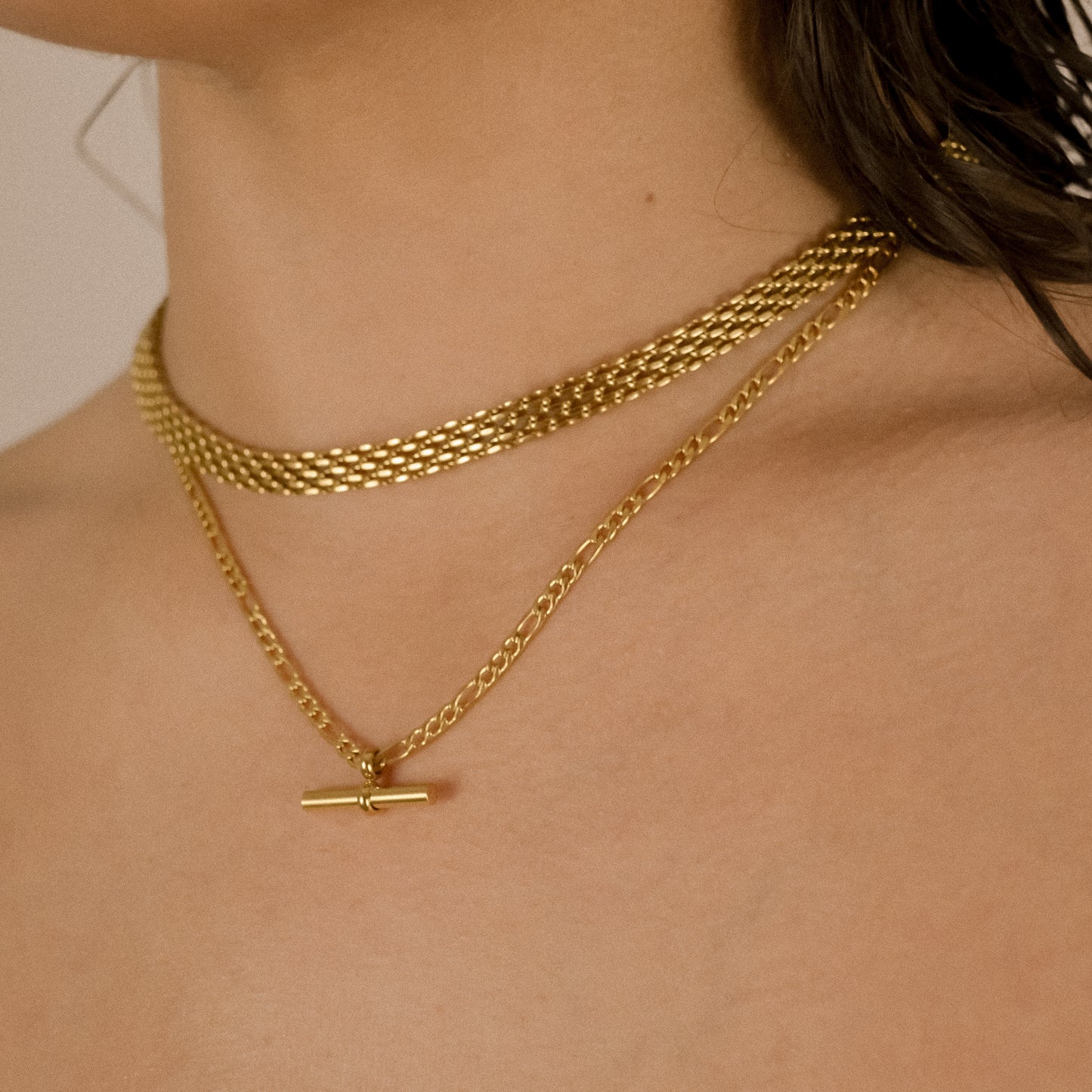 model wearing layered chunky gold chains 