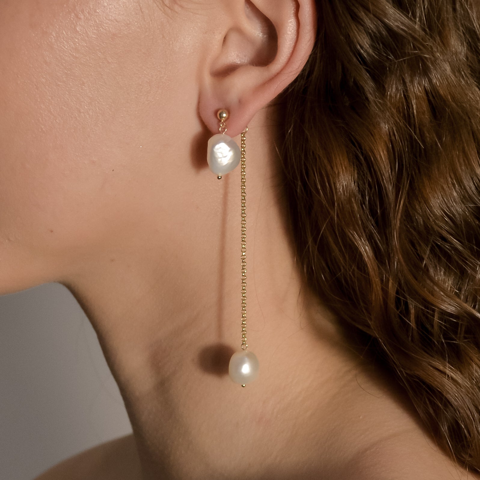 model wearing Lennon gold chain pearl drop earrings 